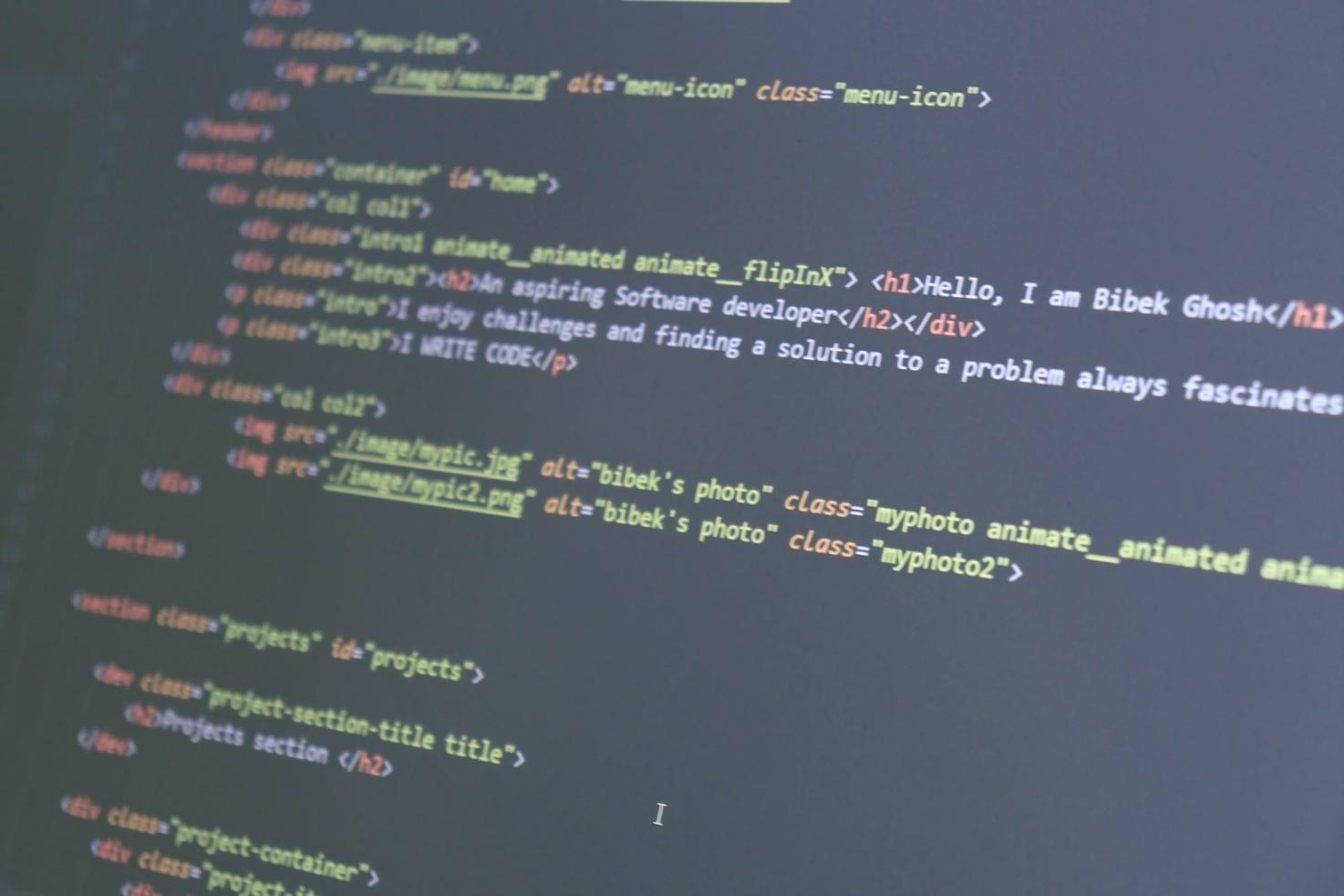 Student working on development project at desk with multiple monitors